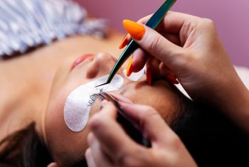 application of eyelash extensions with tweezers, concept of beauty and wellness