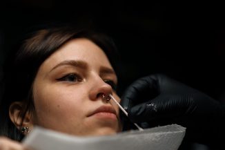 Piercing studio Professional nose piercing for a girl after the procedure the master processes girl's nose septum
